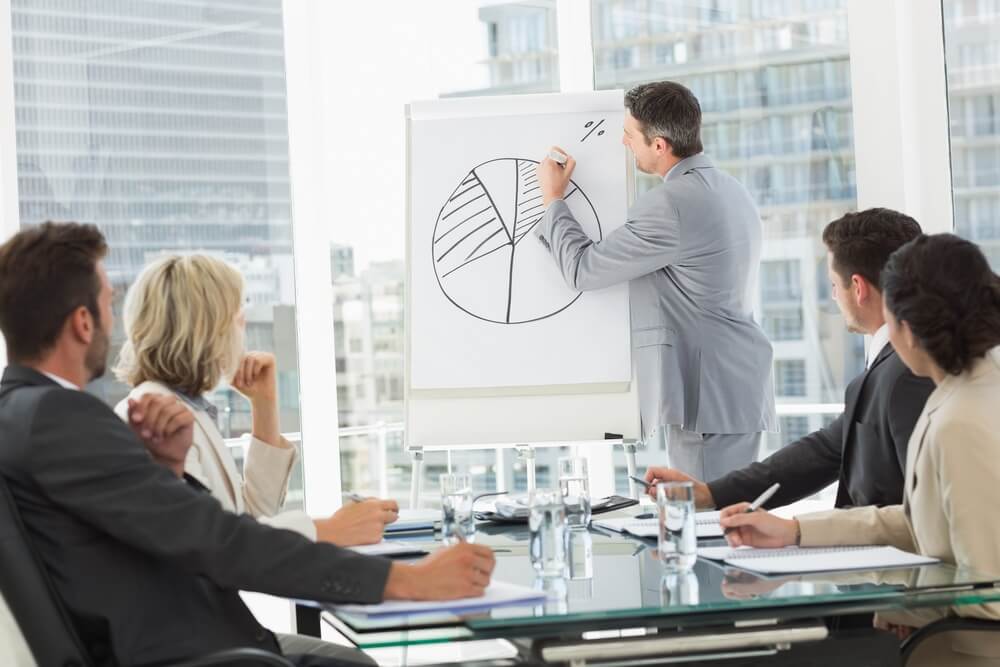 business man drawing pie chart in a meeting presentation