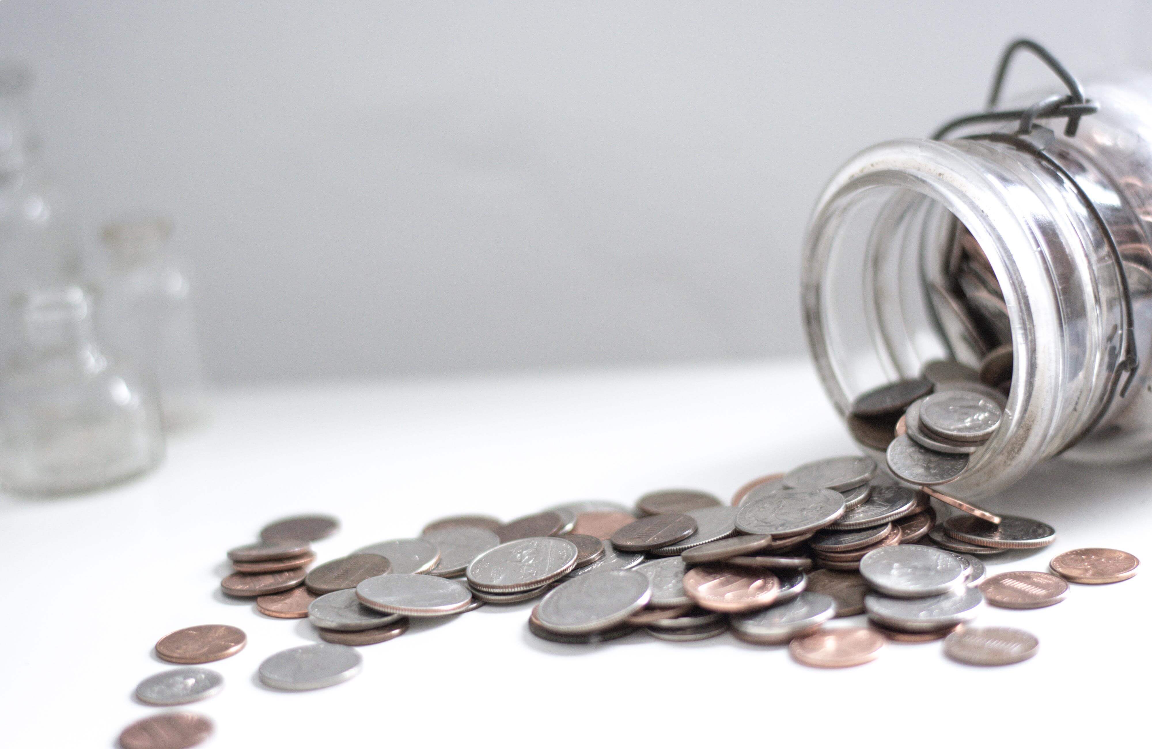 coins spilling out of a mason jar