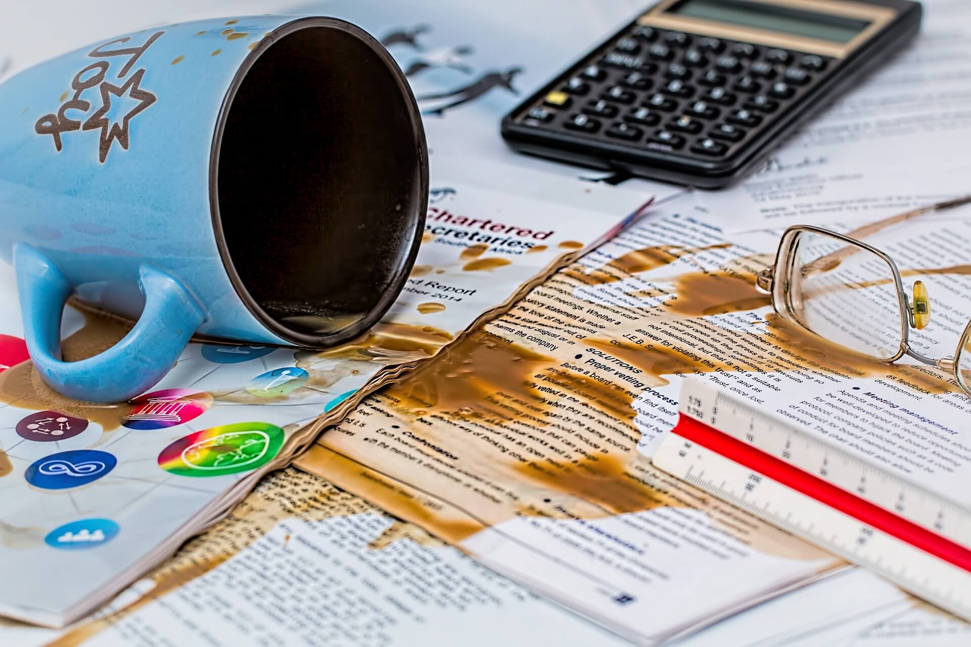cup of coffee spilled over documents on a desk